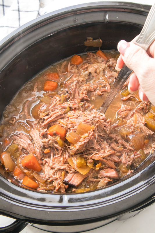 ladle grabbing spoonful of pot roast from slow cooker