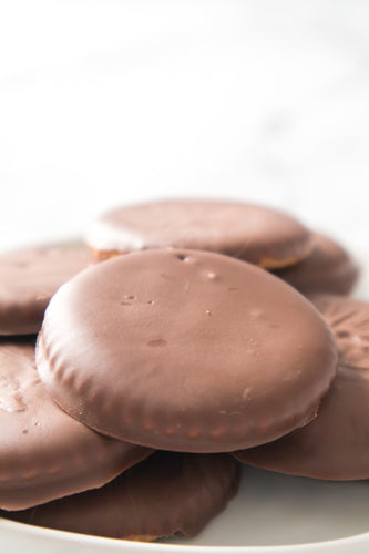 homemade thin mint cookies stacked on top of one another on white plate