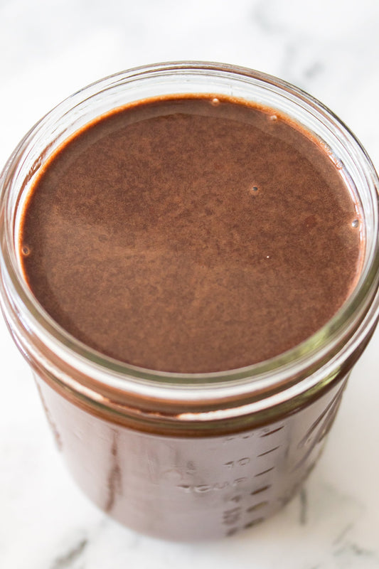 close up vertical shot of chocolate syrup in mason jar