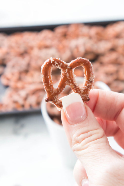 hand holding a baked cinnamon sugar pretzel