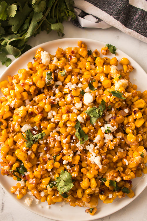 close up shot of Mexican street corn on white plate