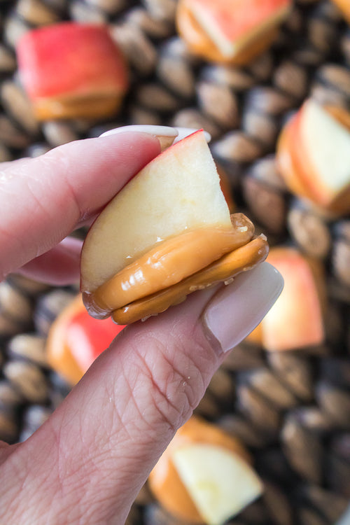 hand holding caramel apple pretzel bite