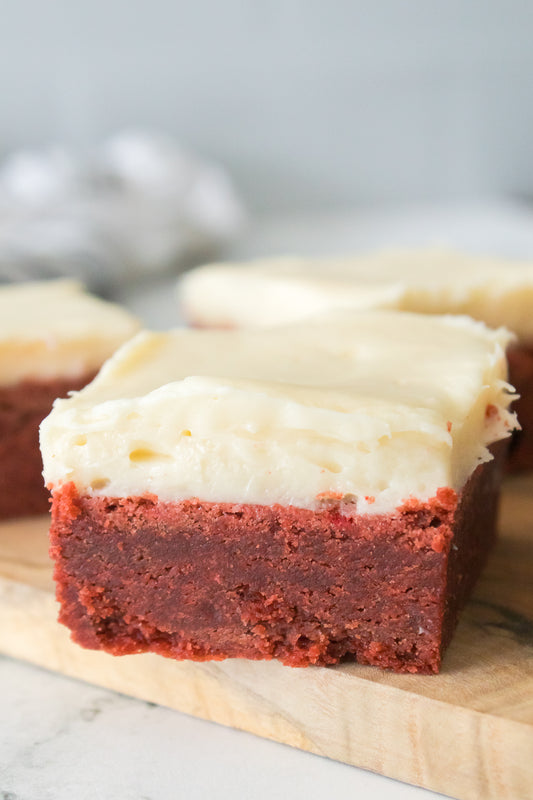 close up vertical shot of texture of red velvet sugar cookie bars with cream cheese frosting