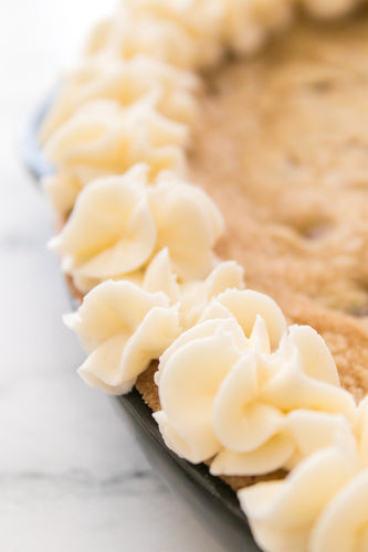 close up shot of white icing piped onto cookie cake