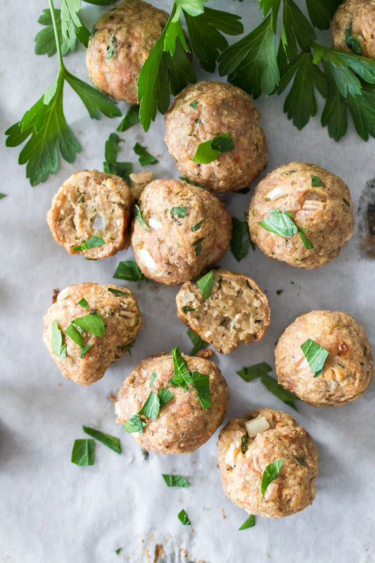 turkey meatballs on parchment paper topped with fresh chopped parsley