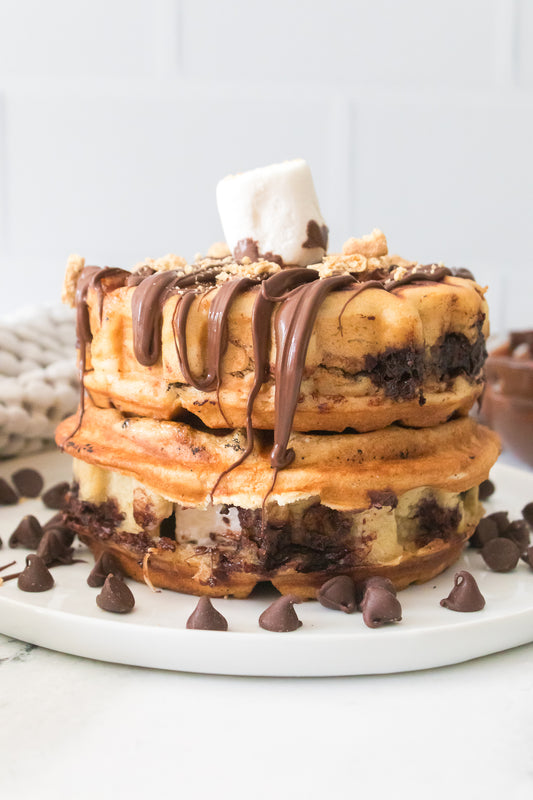 vertical head on shot of stuffed smores waffle topped with melted chocolate chips and a jumbo marshmallow