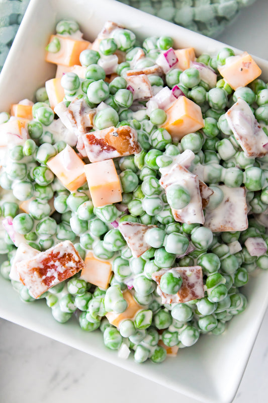 close up overhead shot of pea salad with bacon in squash serving dish